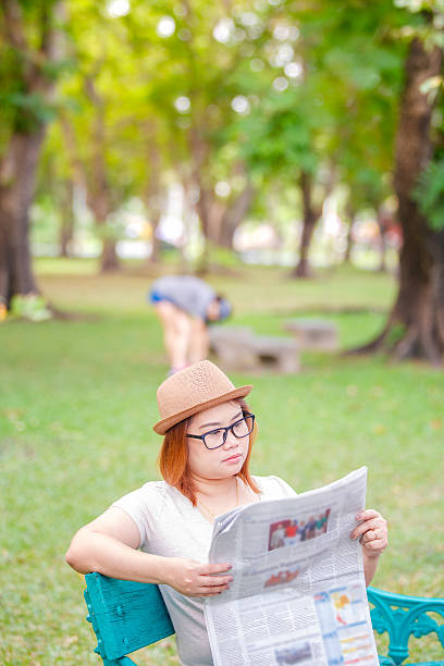 istock Asian female sitting on a wooden bench 618321528