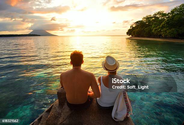 Happy Couple On The Pier On Background Colorful Sunset Stock Photo - Download Image Now
