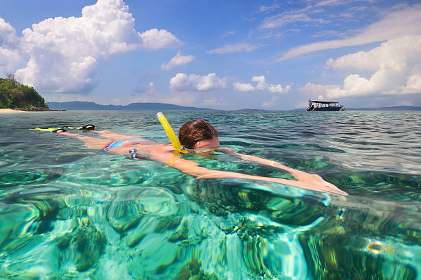istock Woman snorkeling in clear tropical waters 618321658