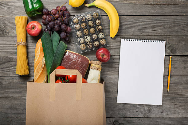 groceries in paper bag on wooden table with blank album - chicken egg audio imagens e fotografias de stock