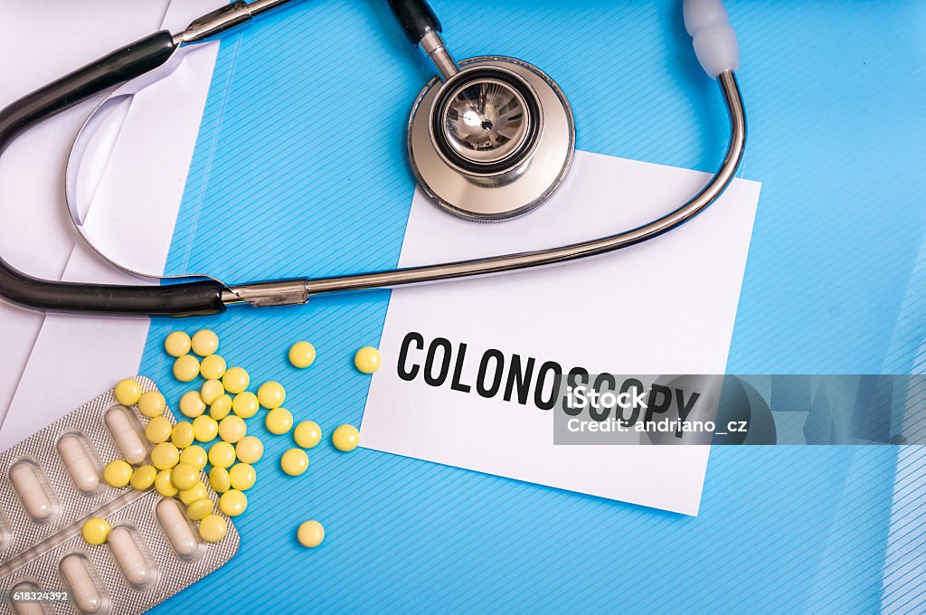 Colonoscopy word written on medical blue folder Colonoscopy word written on medical blue folder with patient files, pills and stethoscope on background Colonoscopy Stock Photo