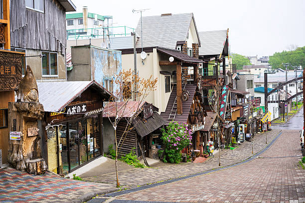 Village Ainu Kotan near lake Akan on Hokkaido, Japan Improvised village of Ainu people used for commercial purposes with lot of shops of the Ainu wood carvings, ornaments, accessories restaurants with traditional Ainu food. The Ainu are indigenous people of Hokkaido, who have completely assimilated into Japanese identity and have not knowledge of their past including language. The same people live in Russia on Sakhalin, the Kuril Islands and Kamchatka. national park akan stock pictures, royalty-free photos & images