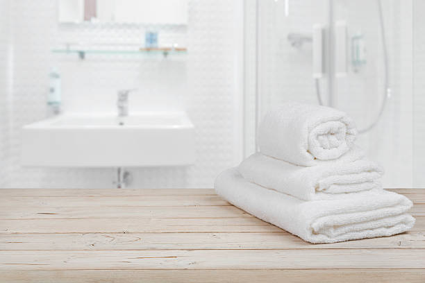 istock Blurred bathroom interior background and white spa towels on wood 618327092