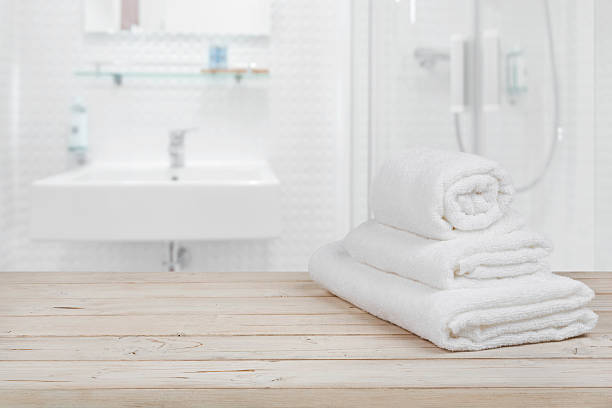 Blurred bathroom interior background and white spa towels on wood Blurred bathroom interior background and white spa towels on wood domestic bathroom stock pictures, royalty-free photos & images