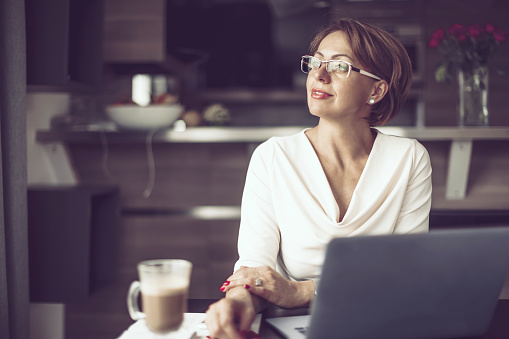 Woman, at home, working, home office, businesswoman, portrait, candid, laptop, computer, social networking, short hair, brown hair, blue eyes, white, caucasian, fancy, 30s, 40s, drinking, coffee