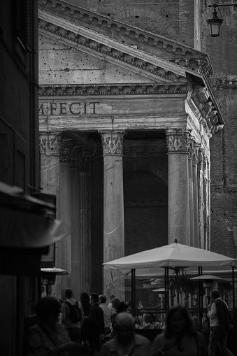 Rome, Italy - October 25, 2016: Right end of the Pantheon and people walking. Scene shot from narrow street called \