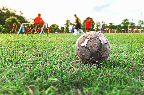 緑の草原の古いサッカーボール - soccer ball old leather soccer ストックフォトと画像
