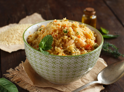 Couscous with shrimps and vegetables in a bowl close up