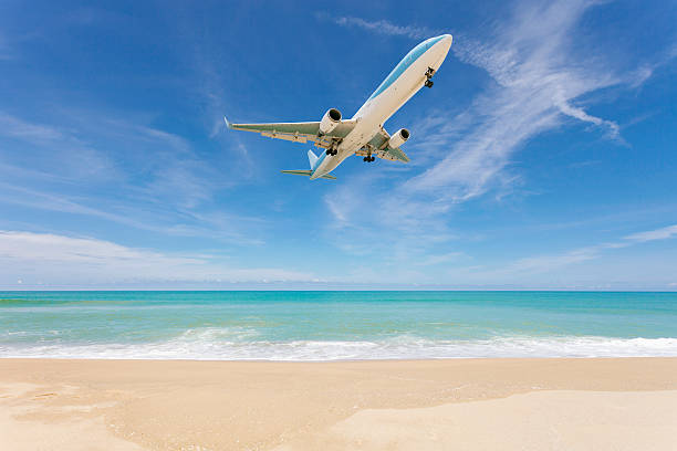 istock Airplane landing above beautiful beach and sea background. 618331456