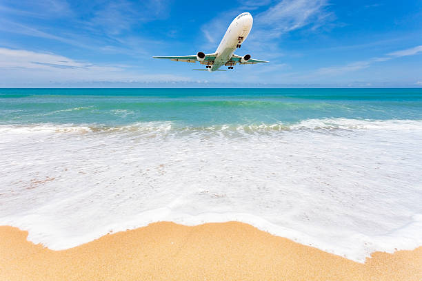 istock Airplane landing above beautiful beach and sea background. 618331664