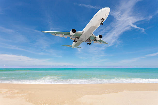 istock Airplane landing above beautiful beach and sea background. 618332852