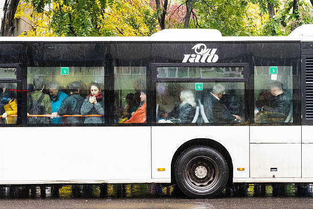 Public transport bus Bucharest, Romania - October 26, 2016: Image of a bus crowded with people in a station in Bucharest on a rainy autumn day. bucharest people stock pictures, royalty-free photos & images