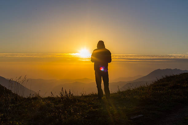 istock Silhouette of one young man standing at the mountain top 618334724