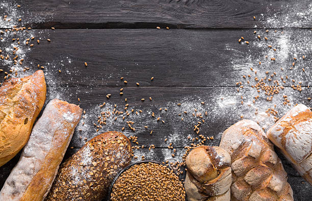 istock Bread bakery background. Brown and white wheat grain loaves composition 618337434