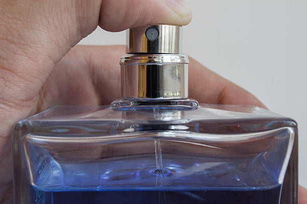 Men's fragrance in his hand Men's fragrance in his hand close-up. Finger presses the diffuser. A small, travel-sized perfume stock pictures, royalty-free photos & images