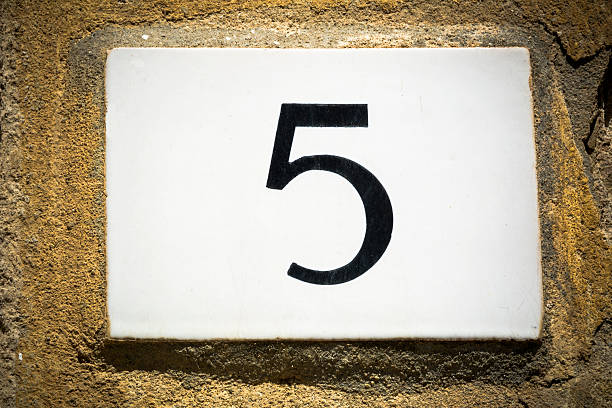 istock Door number five sign on weathered wall 618339832