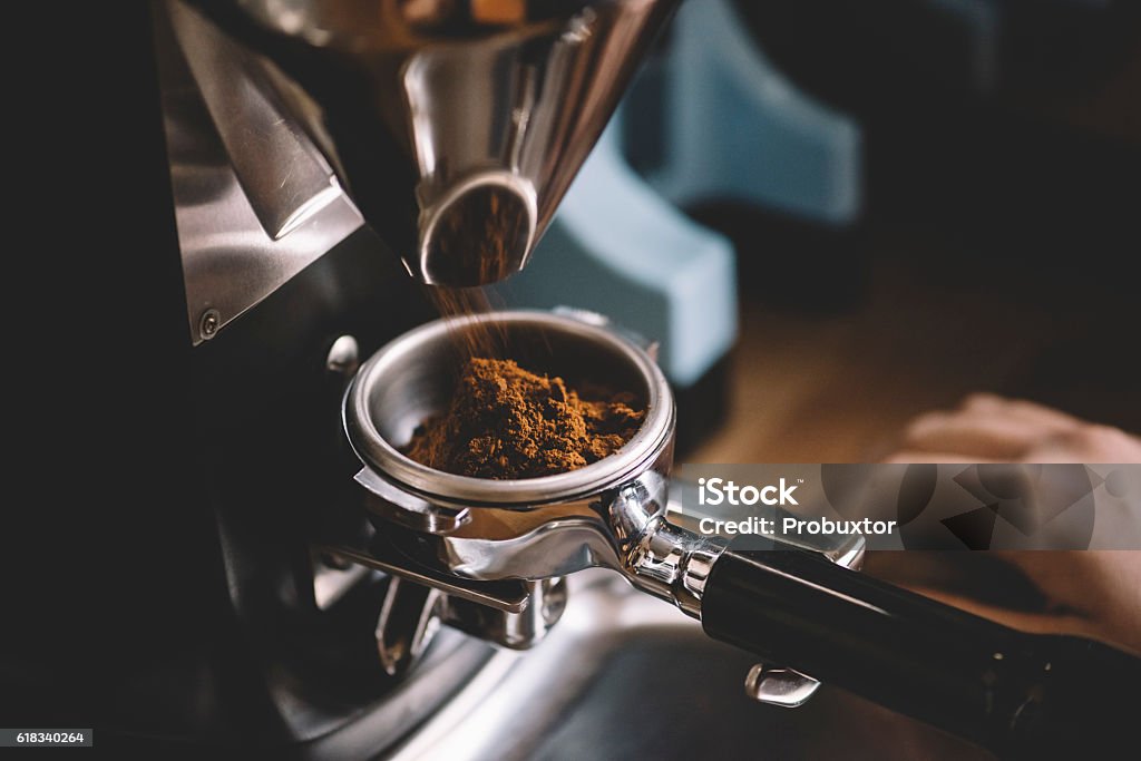 Coffee beans in a portafilter by the coffee grinder freshly ground coffee beans in a portafilter by the coffee grinderfreshly ground coffee beans in a portafilter by the coffee grinderfreshly ground coffee beans in a portafilter by the coffee grinder Coffee - Drink Stock Photo