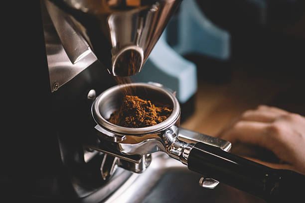 Coffee beans in a portafilter by the coffee grinder freshly ground coffee beans in a portafilter by the coffee grinderfreshly ground coffee beans in a portafilter by the coffee grinderfreshly ground coffee beans in a portafilter by the coffee grinder grinder stock pictures, royalty-free photos & images