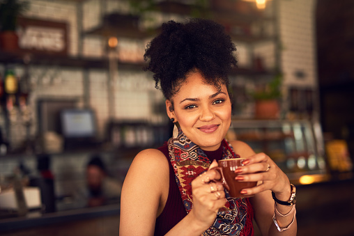 Portrait of an attractive young woman enjoying a cup of coffee in a cafe