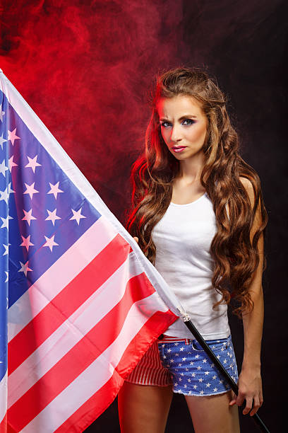 istock Girl holding US flag on flagpole 618341850