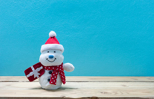 istock snowman holding a Christmas present on wood 618346478