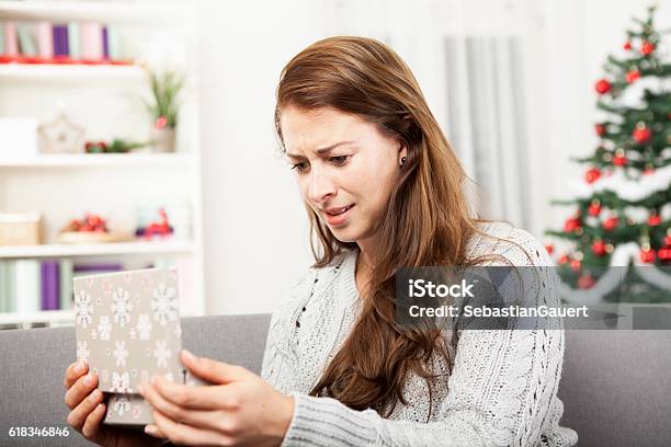 Young Girl Is Unhappy About Her Christmas Gift Stock Photo - Download Image Now - Gift, Disappointment, Rudeness