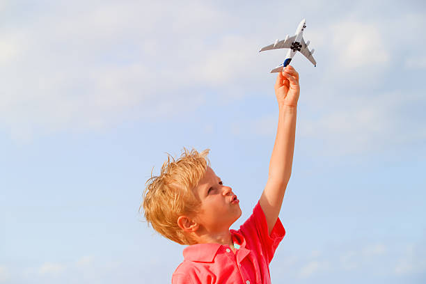 istock Happy kid playing with toy airplane on blue sky 618347304