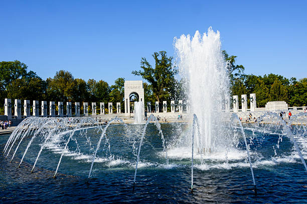 Lincoln Memorial in Washington, D.C., with large fountain of water at the WWII Memorial in the foreground.  Overcast sky, early morning, no people.