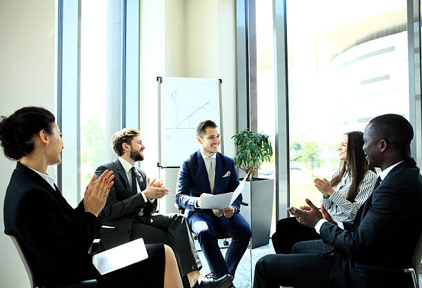 istock Group of young people discussing something while sitting in office 618348004
