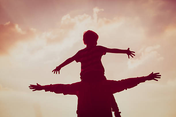 istock father and son play on sunset sky 618348078