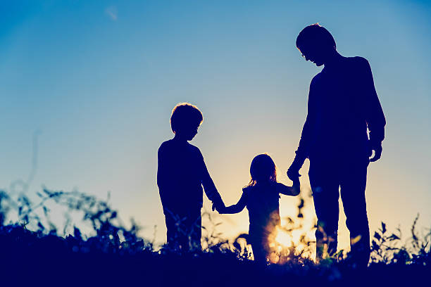 istock father with son and daughter walk at sunset 618348204