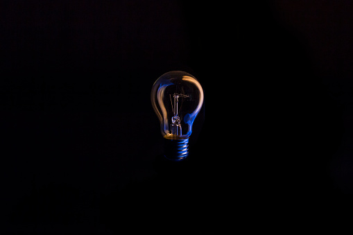 Tungsten light bulb with beautiful blue and yellow reflections.