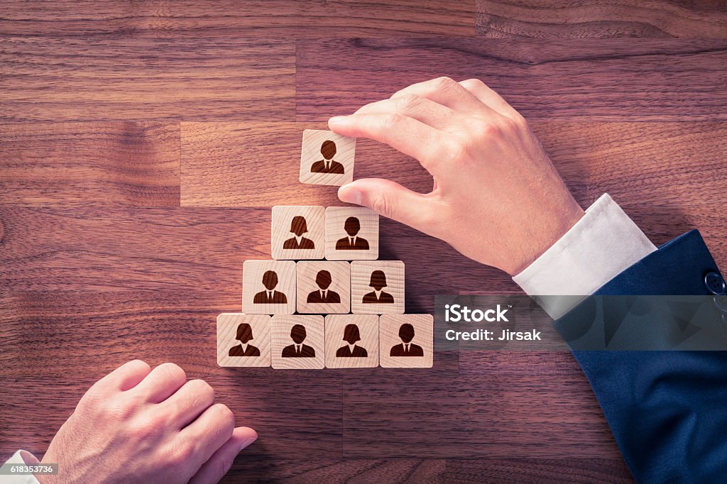 Human resources and CEO Human resources and corporate hierarchy concept - recruiter complete team by one leader person (CEO) represented by icon. Corporate Hierarchy Stock Photo