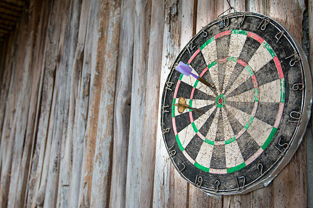 istock Old dart board on wooden background 618354394