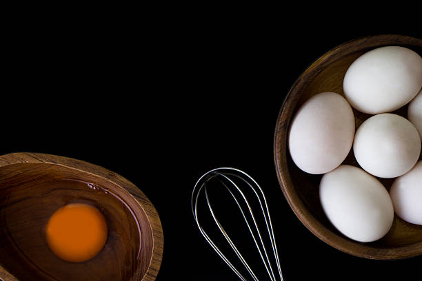istock White Egg in wooden teak bowl whisk on black background 618354996