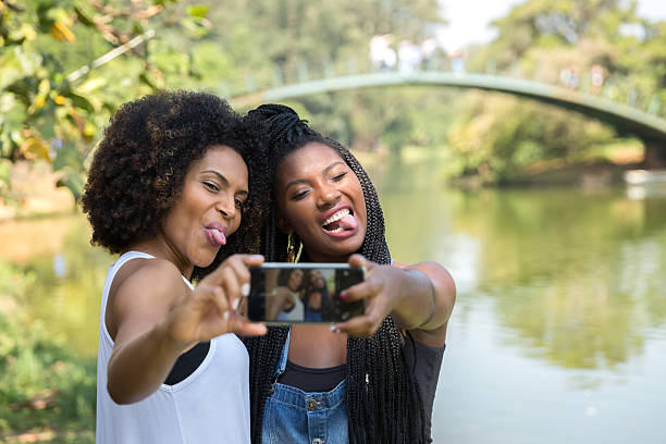 mulheres afro tirando fotos de selfie no parque - indigenous culture nigerian culture african descent nigeria - fotografias e filmes do acervo