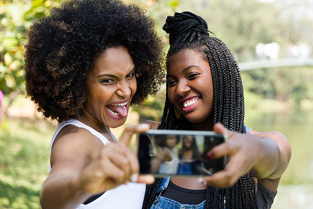 mulheres afro tirando fotos de selfie no parque - indigenous culture nigerian culture african descent nigeria - fotografias e filmes do acervo