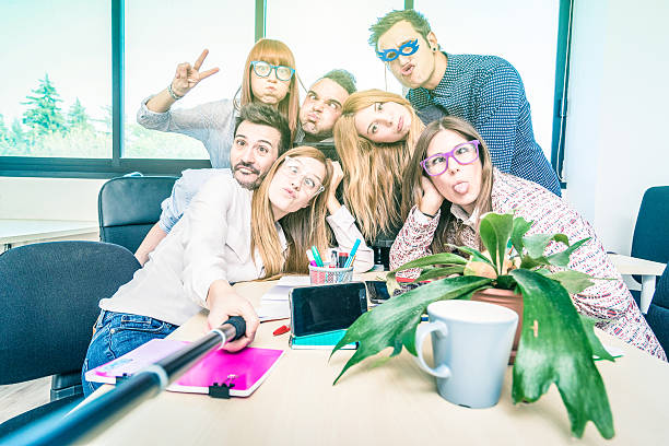 Group of happy students employee workers taking selfie at work