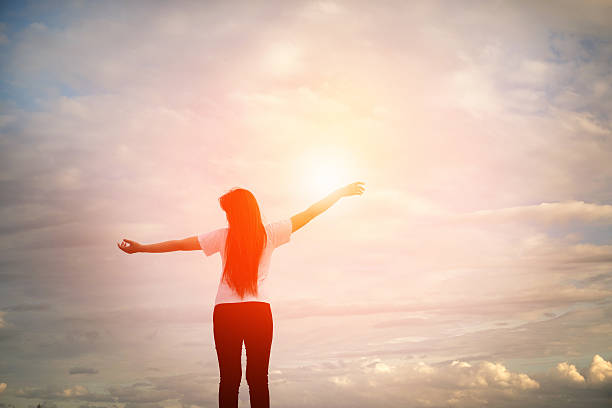 istock silhouette Young women raise hands up for her success Concept 618360180
