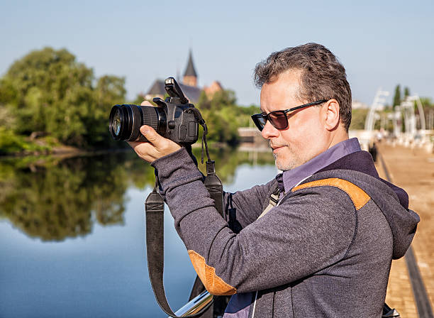 istock elderly man photographs the landscape 618361456