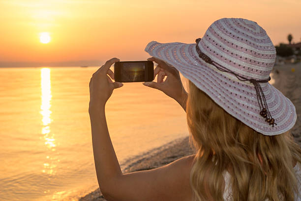 istock Woman picturing Sunrise on the beach. 618362770