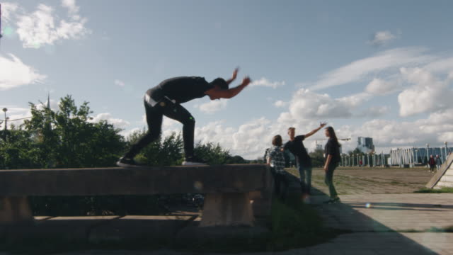 Young Male Freerunner Performing Tricks and Jumps Outdoors in Urban Environment.