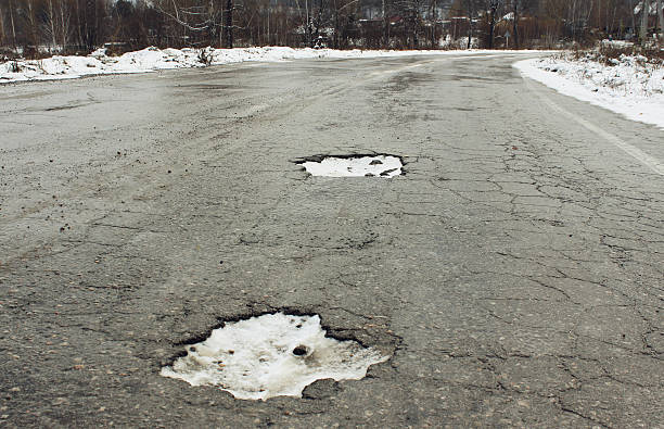istock Large pit on the old road in the winter 618419138