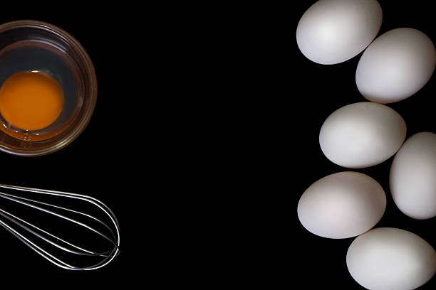 istock White Egg small wooden teak bowl whisk on black background 618422836