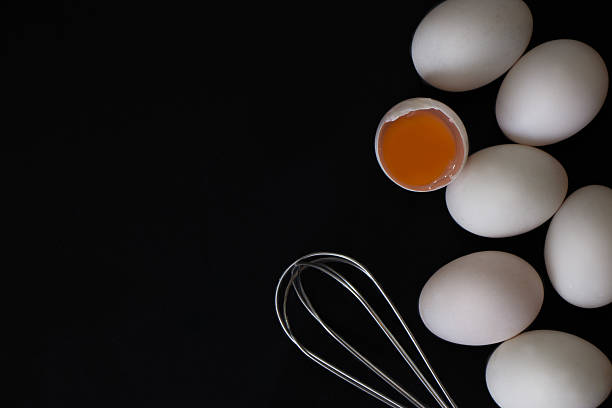 istock White Egg small wooden teak bowl whisk on black background 618422864