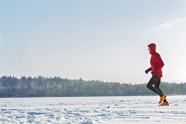 Corredor de carreras de trail con ropa deportiva en sesión de entrenamiento de invierno al aire libre - foto de stock