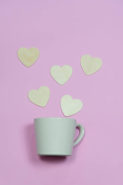 istock Coffee cup with heart wooden shape on pink background 618423892