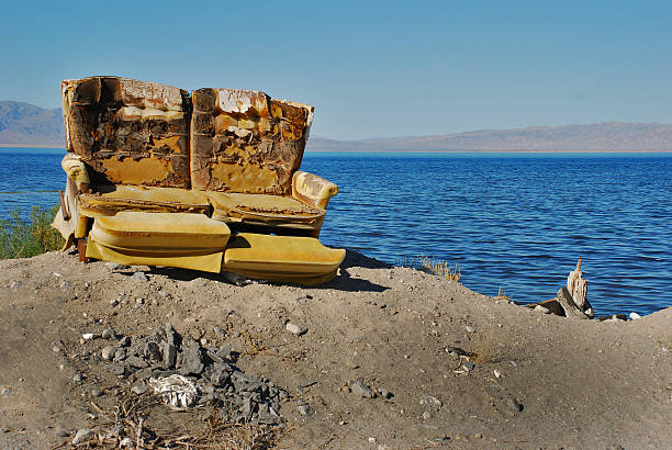 vecchio posto d'amore intemperie al salton sea - burnt furniture chair old foto e immagini stock