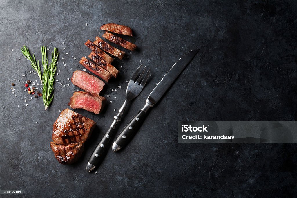 Grilled sliced beef steak Grilled sliced beef steak on stone table. Top view with copy space Steak Stock Photo