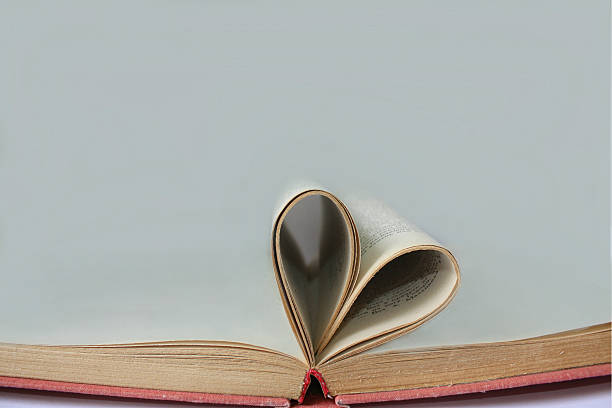 istock Pages of open book rolled in heart shape 618429038